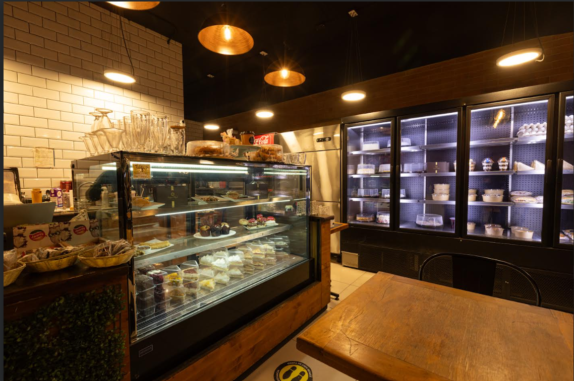 Interior de Woody Coffee con vitrina de pastelería